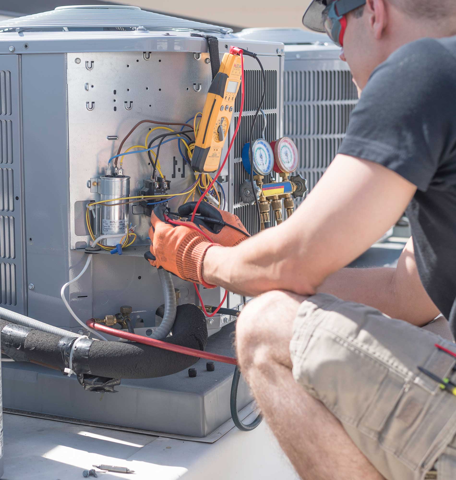 HVAC technician working on controls of air conditioner HVAC technician working on controls of air conditioner